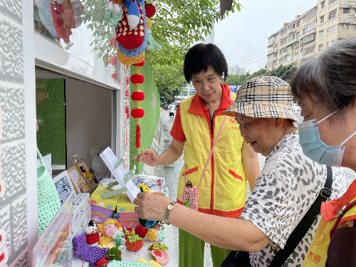 （圖：社區(qū)居民挑選義賣品）.png