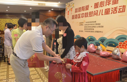 圖：與會領(lǐng)導(dǎo)為兒童贈送慰問品.png