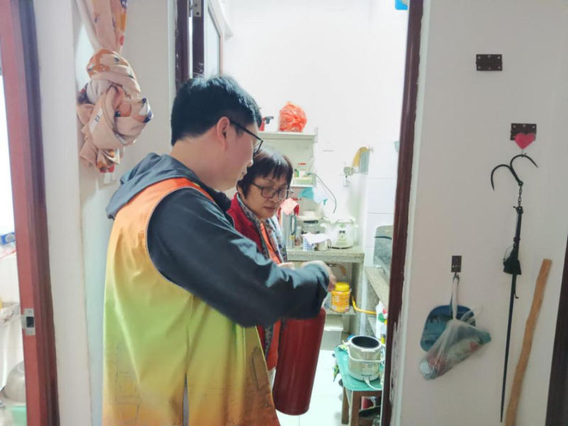 工作人員正在講解煙感報警器和滅火器的使用方法.png