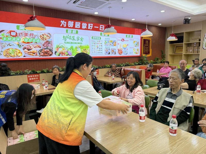 圖：社區(qū)工作者為居民派發(fā)活動(dòng)紀(jì)念品.jpg