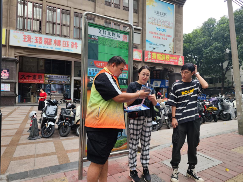 社區(qū)工作人員在文昌北路公交站向居民群眾派發(fā)禁毒、防詐騙資料.png