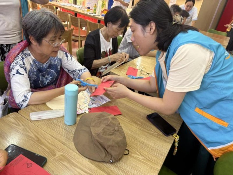 圖：工作人員指導居民完成剪紙的細節(jié)部分.jpg
